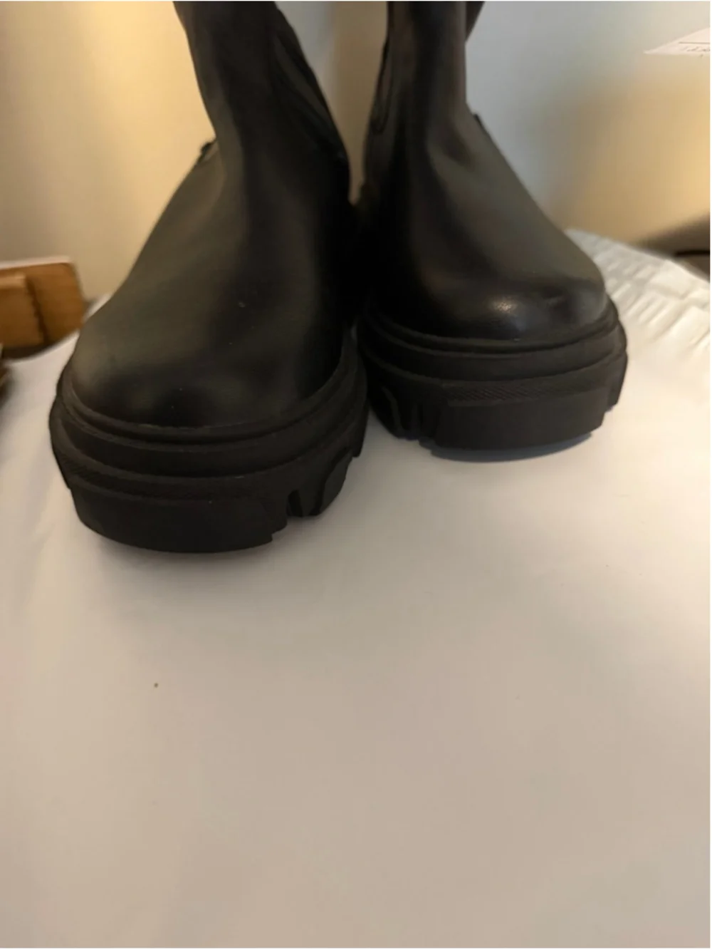 Calvin Klein black chunky platform boots featuring a thick, ridged lug sole.